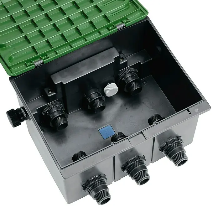 Gardena Sprinklersystem Ventilbox V3 - Passend für: 3 Bewässerungsventile - Ein offener, grauer Bewässerungsverteilerkasten mit grünem Deckel zeigt mehrere Anschlussstellen. Perfekt für die Gartenbewässerung.