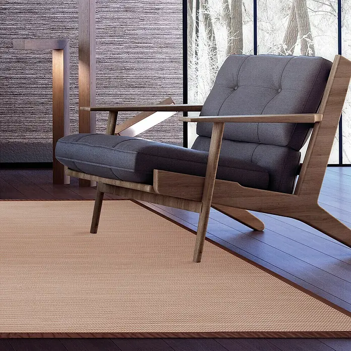 Alfombra de vinilo Living Sisal - Marrón, 230 x 160 cm - Un sillón elegante hecho de madera clara con cojines grises se encuentra sobre una alfombra, invitando a la relajación. Ofrece comodidad y es atractivo.