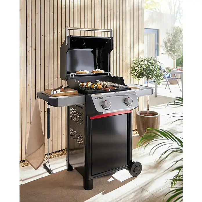 Weber Gasgrill Spirit E-210 - Grillfläche (B x T): 52 x 44 cm, 7,8 kW, Anzahl Brenner: 2 Stk. - Weber Spirit Gasgrill mit offenem Deckel, Zubehör und Grillgut auf dem Rost. Perfekt für gemütliche Grillabende im Freien.
