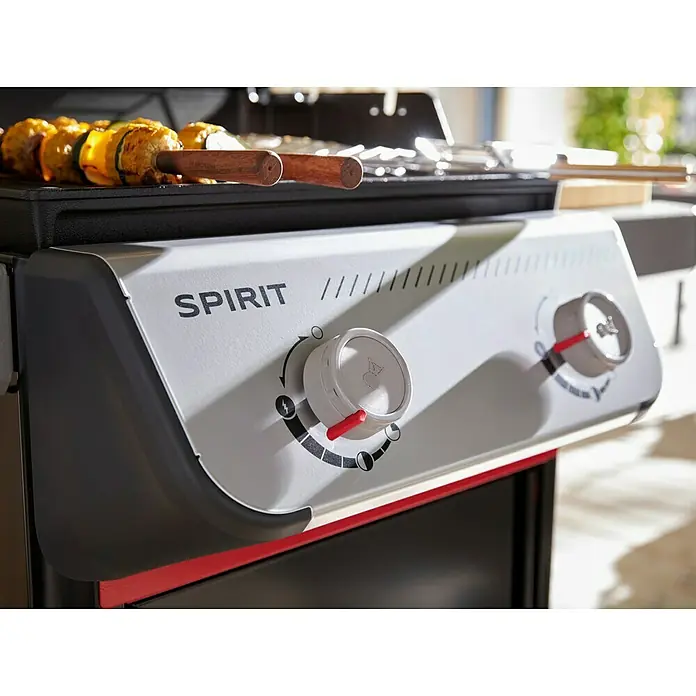 Weber Gasgrill Spirit E-210 - Grillfläche (B x T): 52 x 44 cm, 7,8 kW, Anzahl Brenner: 2 Stk. - Nahaufnahme eines Weber Spirit Gasgrills mit Drehknöpfen und Spießen auf dem Grillrost.