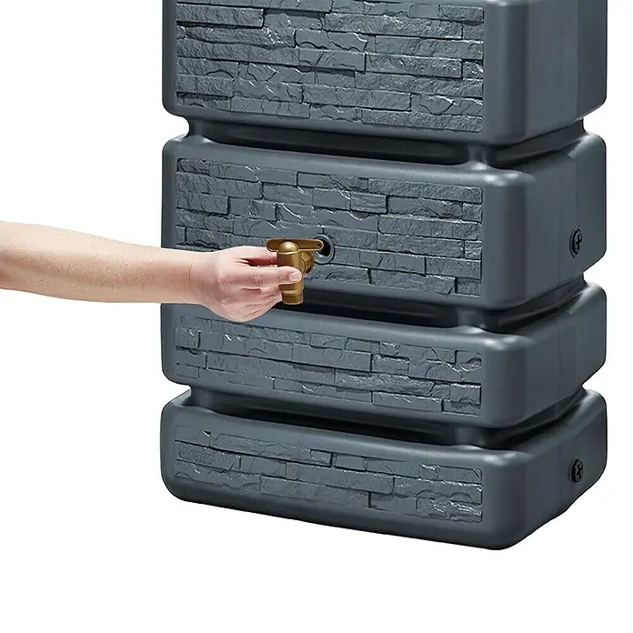 4rain Regenspeicher Slim Stone - 350 l, Graphitgrau, 1 Stk. - Nahaufnahme eines grauen Regentonnenmoduls mit Steinmuster und einem bronzefarbenen Wasserhahn, der von einer Hand bedient wird.