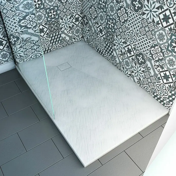 Aurlane Duschwanne Stone - L x B: 140 x 90 cm, High Pressure Tech, Weiß - Hellgraue, strukturierte Duschwanne mit linearem Abfluss in einem Bad mit gemusterten Wand- und dunklen Bodenfliesen.