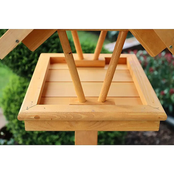 Promadino Vogelhaus Rhön - 42 x 36 x 38 cm, Holz, Braun, Ausstattung: Ohne Vogelhausständer - Nahaufnahme eines hölzernen Vogelhauses mit Futterstelle und Dach, das in einem Garten steht.