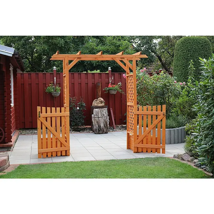 Promadino Pergola Bamberg - Höhe: 208 cm, Ausführung: Tür & Pflanzkasten - Einladender Garteneingang mit einem hölzernen Torbogen, der zu einem gepflasterten Weg und einem üppigen Garten führt.