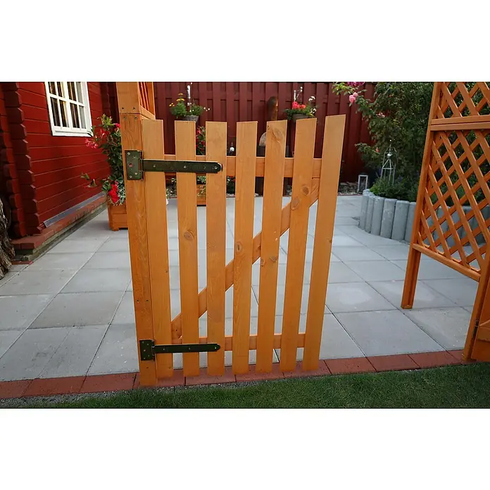 Promadino Pergola Bamberg - Höhe: 208 cm, Ausführung: Tür & Pflanzkasten - Ein hölzernes Gartentor mit Metallscharnieren trennt den Gartenweg. Das Tor ist hellbraun und passt zum Gesamtbild des Gartens.