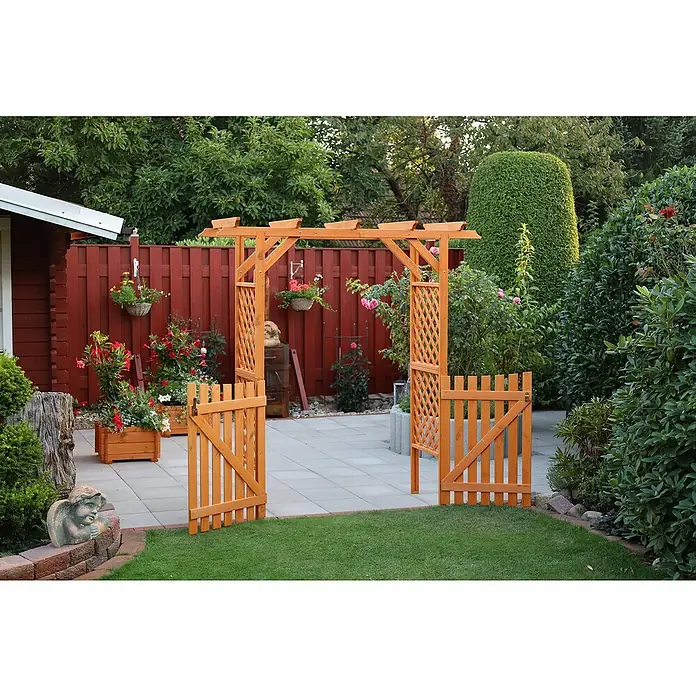 Promadino Pergola Bamberg - Höhe: 208 cm, Ausführung: Tür - Ein Gartentor aus Holz mit Rankgitter und einem Rosenbogen, umgeben von blühenden Pflanzen und einem gepflegten Garten mit grüner Rasenfläche.