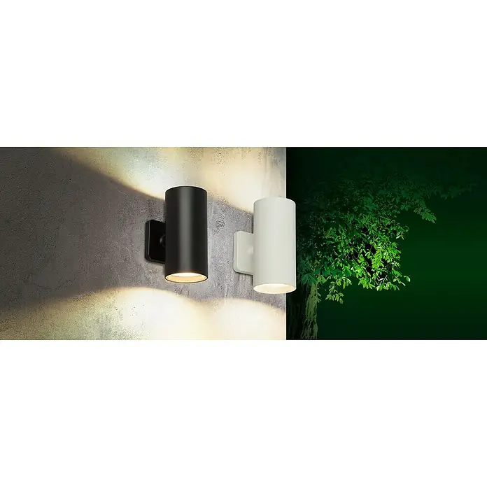 Starlux Akku-Wandleuchte Avio - 2,6 W, 7,1 x 5,3 x 11 cm, IP44, Schwarz - Moderne Außenleuchten: Eine schwarze und eine weiße zylindrische Wandleuchte beleuchten eine graue Wand und das Grün eines Baumes.
