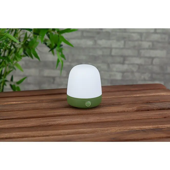 Starlux Akku-Tischleuchte Mini - L x B x H: 10 x 10 x 12 cm, Matcha Green, RGBW, 0,3 W, IP44 - Grüne und weiße Tischleuchte mit abgerundeten Kanten, die auf einem Holztisch steht und ein weiches, warmes Licht ausstrahlt.