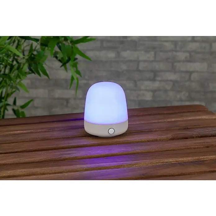 Starlux Akku-Tischleuchte Mini - L x B x H: 10 x 10 x 12 cm, Beige, RGBW, 0,3 W, IP44 - Nahaufnahme einer leuchtenden, farbwechselnden Lampe. Perfekt für Kinderzimmer oder als Nachtlicht.