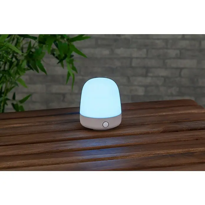 Starlux Akku-Tischleuchte Mini - L x B x H: 10 x 10 x 12 cm, Beige, RGBW, 0,3 W, IP44 - Tischleuchte mit warmem Licht auf einem Holztisch. Eine moderne, sanfte Beleuchtung für eine gemütliche Atmosphäre.