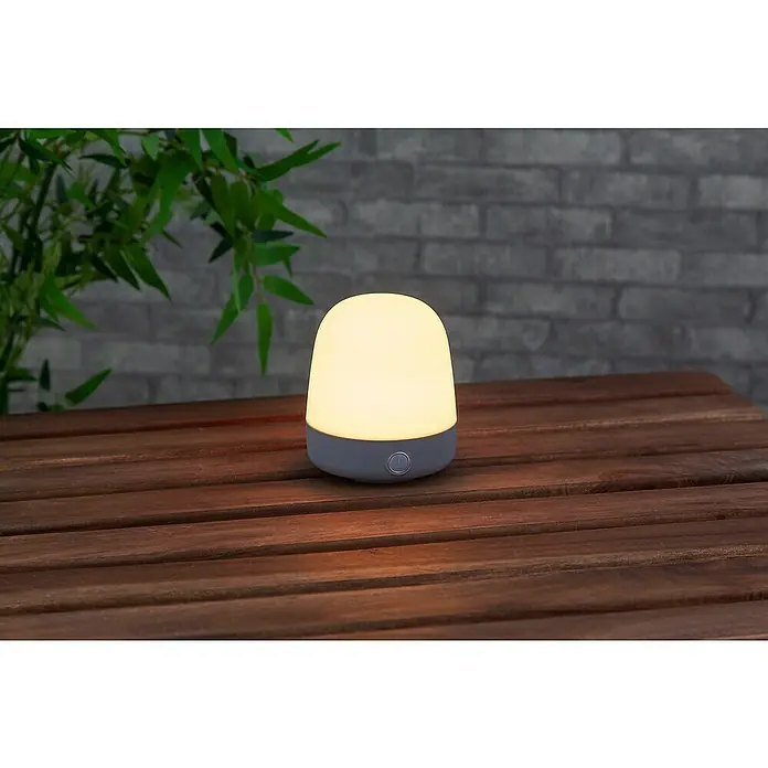 Starlux Akku-Tischleuchte Mini - L x B x H: 10 x 10 x 12 cm, Light Grey, RGBW, 0,3 W, IP44 - Tischleuchte mit sanftem Licht auf einem Holztisch, ideal für stimmungsvolle Abende.