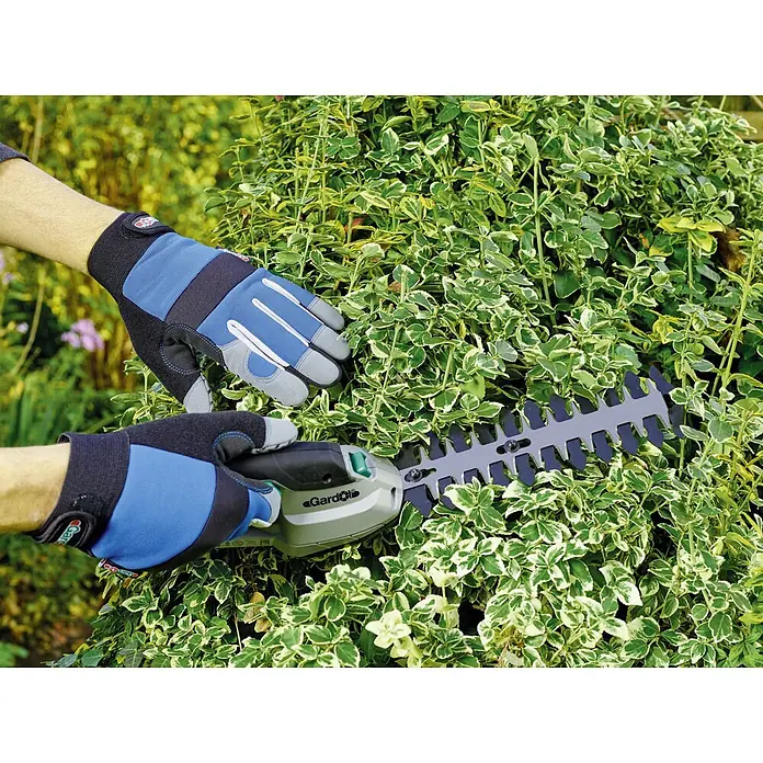 Gardol Gartenhandschuhe Geräte - 10, Blau - Eine Gardol Heckenschere wird von zwei behandschuhten Händen benutzt, um einen Busch zu stutzen.