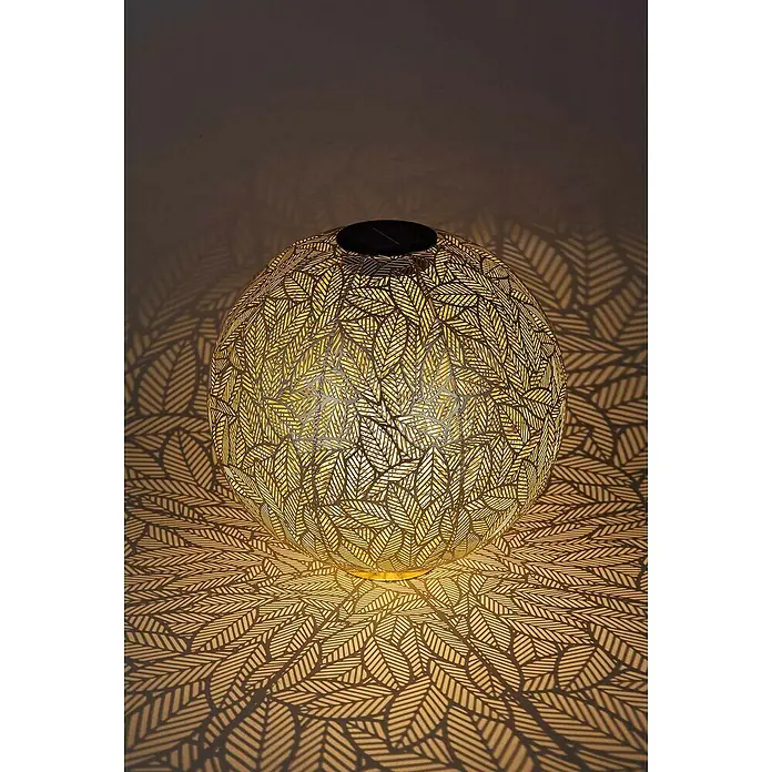 BAUHAUS Solar-Dekoleuchte Blätter - 0,5 W, L x B x H: 30 x 30 x 30 cm, Champagne, IP44 - Nahaufnahme einer Solarleuchte in Kugelform mit Blättermuster, die ein dekoratives Schattenmuster erzeugt.