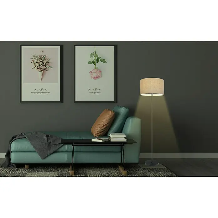 Tween Light Stehleuchte Nava - 40 W, Höhe: 146 cm, Schwarz, Beige, E27 - Türkisfarbenes Sofa mit braunem Kissen und grauer Decke, Beistelltisch mit Büchern, Stehlampe und zwei gerahmten botanischen Drucken in einem gemütlichen Wohnzimmer.