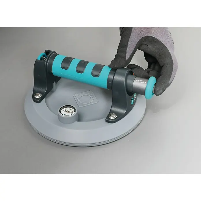 Bihui Saugheber SCVB8 - Tragkraft: 110 kg - Behandschuhte Hand bedient einen türkis-schwarzen Vakuum-Saugnapfheber mit grauem Pad und Manometer.