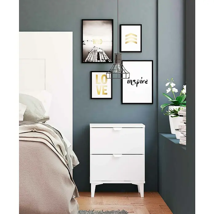 Meka Block Cómoda K-914 con mesitas de noche K-913 - Blanco poro, 3 pzs. - Interior de dormitorio con mesita de noche blanca de dos cajones y cuadros decorativos en la pared.