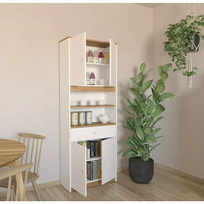 Meka Block Aparador buffet K-1100 - L x An x Al: 29,2 x 67,2 x 180 cm, Blanco/Roble Albar - Una despensa blanca con detalles de madera, parcialmente abierta, que muestra bebidas, platos y libros. Una planta de interior se sienta al lado.
