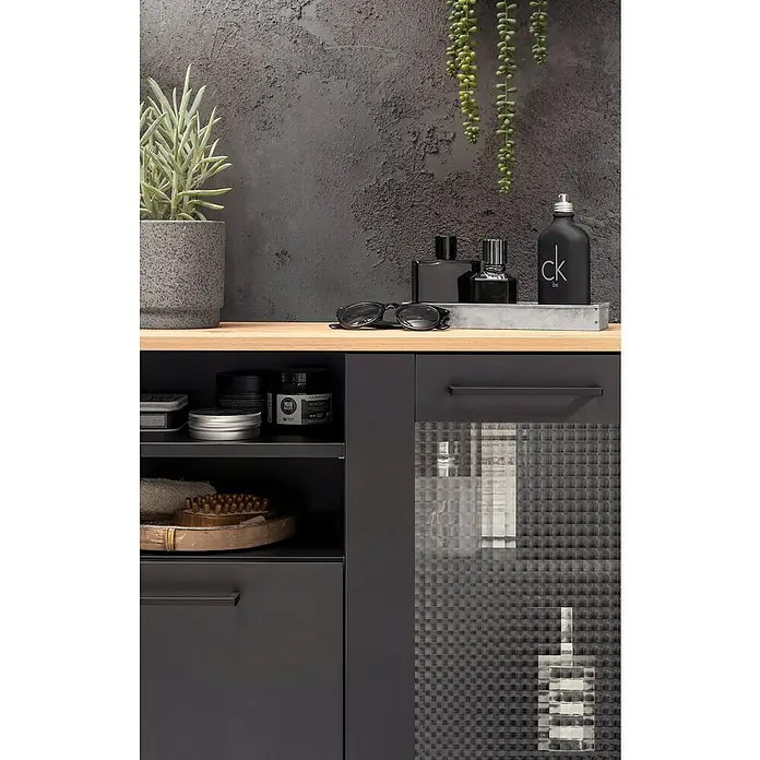 Schildmeyer Malte Highboard - B x T x H: 80,4 x 32 x 70 cm, Schwarz/Artisan Eiche, Matt - Dunkelgrauer Badezimmerschrank mit Holzplatte, offenen Fächern und strukturierter Glastür, der Pflegeprodukte enthält.