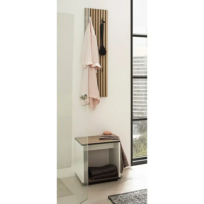 Schildmeyer Katta Badhocker - B x H: 40 x 42 cm, Weiß/Braun - Wandpaneel aus Holzlamellen mit schwarzen Haken für Bademantel und Bürste, über passender Sitzbank mit Handtüchern im Bad.