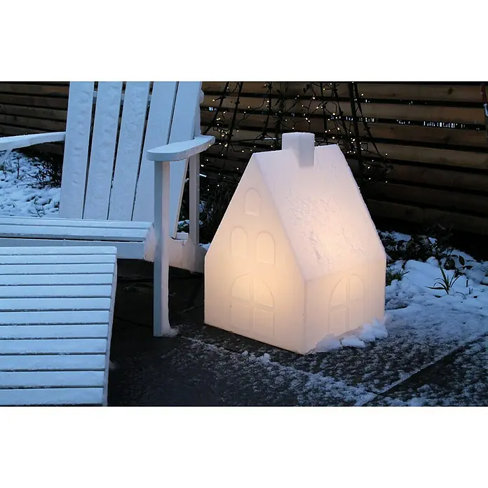 8 Seasons Design Shining LED-Solar-Dekoleuchte House - 2 W, Weiß, L x B x H: 39 x 39 x 57 cm - Festliche Outdoor-Szene mit einem leuchtenden Haus und einem verschneiten Stuhl, die eine winterliche Atmosphäre erzeugen.