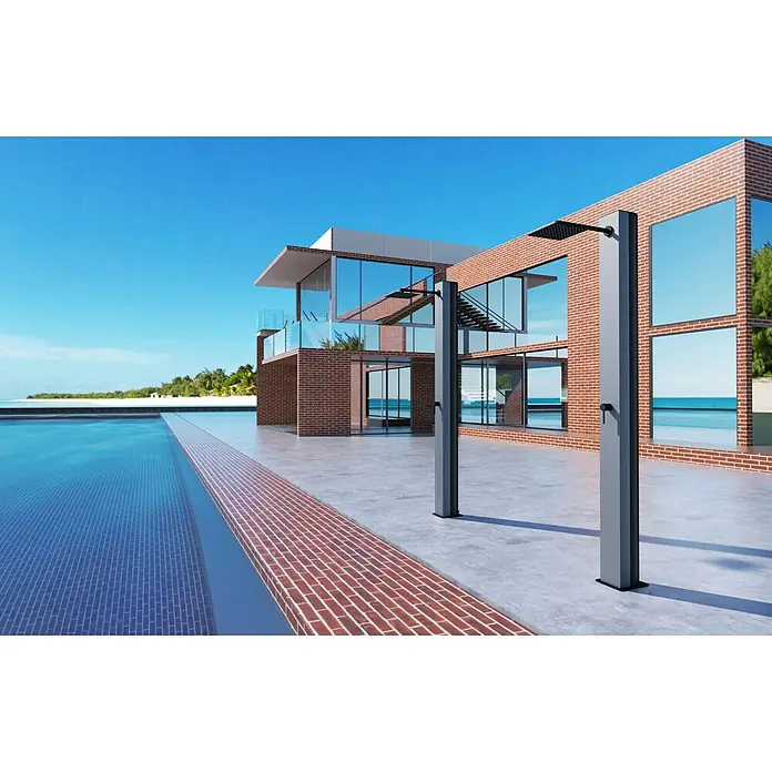 Imex Poolimex Ducha de piscina Phoenix - 222 cm, Aluminio, Gris cobalto - La imagen muestra una casa moderna con una piscina y dos duchas exteriores hechas de metal gris. El cielo es azul y el agua es clara.