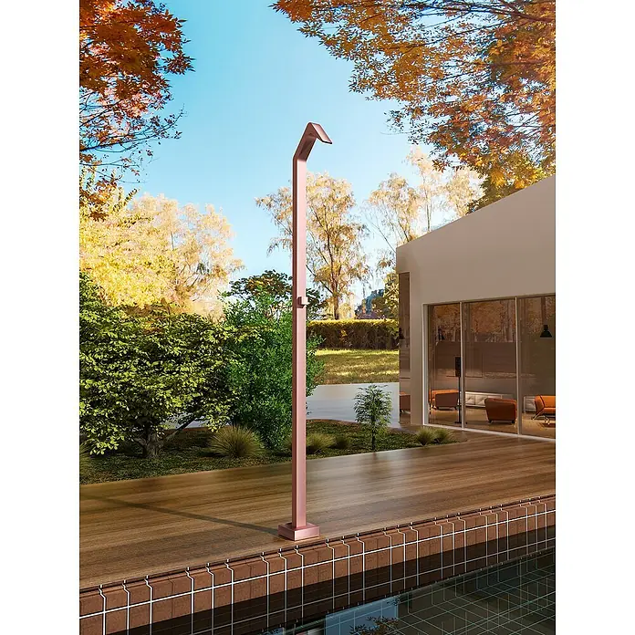 Imex Poolimex Ducha de piscina Niagara - 218 cm, Acero inoxidable, Rosa coral - Una ducha exterior moderna de color cobre se alza sobre una terraza de madera junto a una piscina y una casa moderna.
