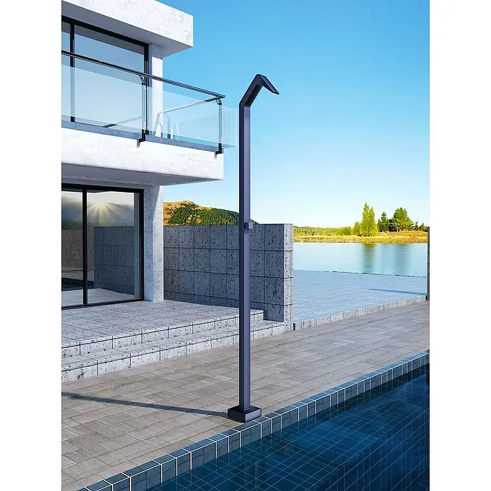 Imex Poolimex Ducha de piscina Niagara - 218 cm, Acero inoxidable, Azul océano - Una ducha exterior moderna de metal oscuro se encuentra junto a una piscina revestida con azulejos azules. La casa tiene balcón.