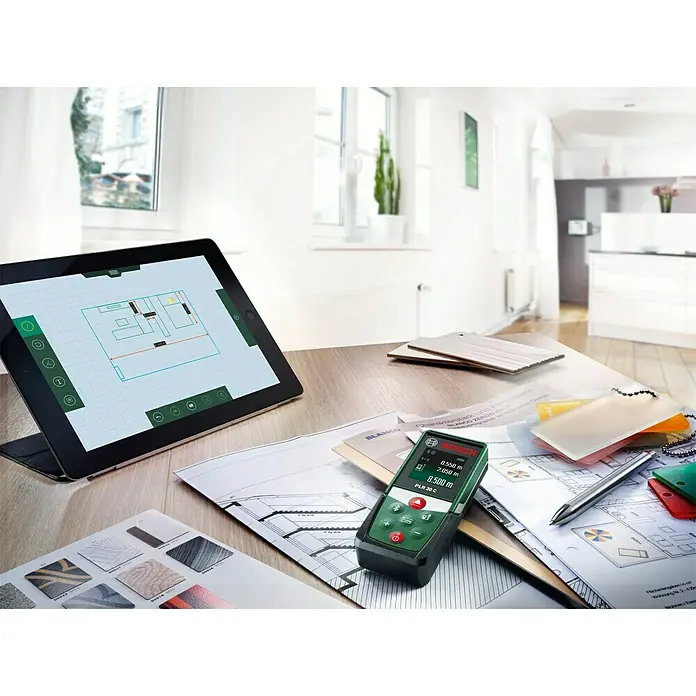 Bosch Medidor de distancia láser PLR 30 C - Gama de medición: 0,05 m - 30 m - Medidor láser Bosch PLR 30 C junto a una tableta con un plano. Medición precisa para una planificación y diseño exactos.
