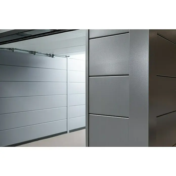 Telluria Garage Classico 3663G inkl. Elektro-Set und Innenwandverkleidung - Außenmaß inkl. Dachüberstand (B x T): 388 x 658 cm, Anthrazit, Stahl, Elektro-Set - Nahaufnahme eines grauen Garagentors mit horizontalen Paneelen, das teilweise geöffnet ist und Einblick in den Garagenraum gewährt.