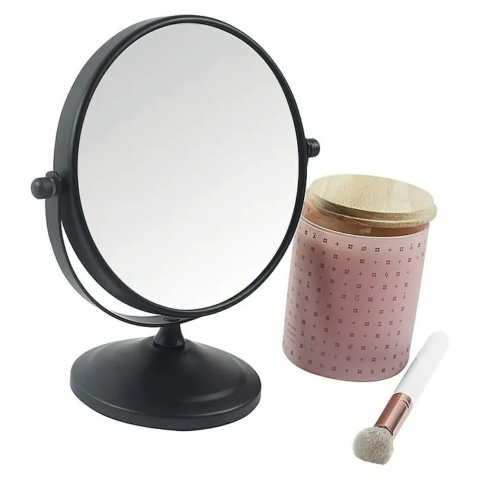Deblanch Espejo cosmético - 15 x 15 cm, Redonda, Negro, Aumento 1: 700 % - Un espejo de maquillaje negro redondo colocado junto a un recipiente rosa con un cepillo.