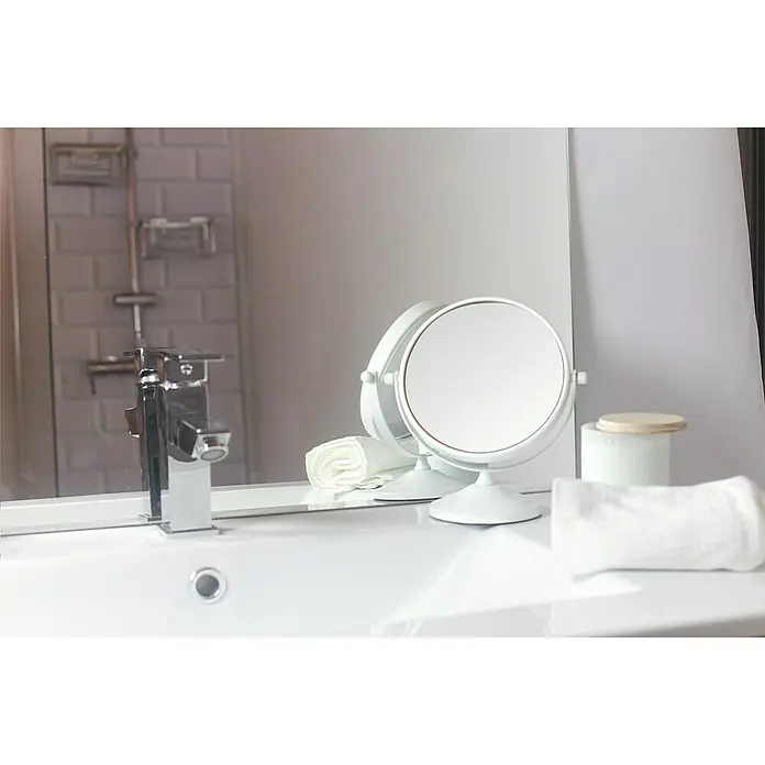 Deblanch Espejo cosmético - 15 x 15 cm, Redonda, Blanco, Aumento 1: 300 %, Aumento 2: 700 % - Un tocador de baño cuenta con un grifo moderno y un espejo de maquillaje redondo y blanco en la encimera junto a las toallas.
