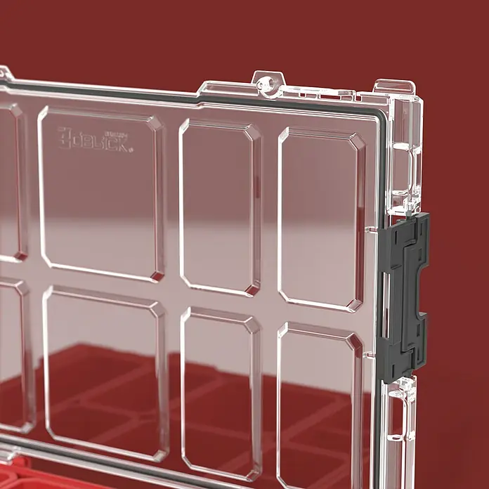 Qbrick System Kleinteilekoffer Pro Organizer 100 - L x B x H: 29,6 x 45 x 7,9 cm, Anzahl Fächer: 8 Stk. - Nahaufnahme eines transparenten Organizer-Boxdeckels mit schwarzem Verschluss, der rote Fächer im Inneren zeigt.