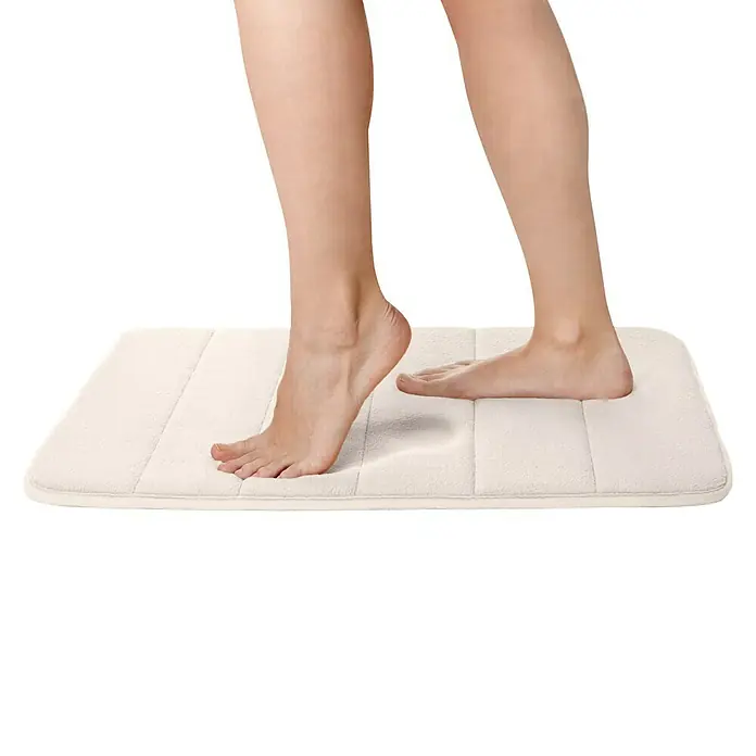 Tatay Alfombra de baño Nuvola - 60 x 40 cm, Poliéster, Blanco - Primer plano de una persona pisando una alfombra de baño blanca y suave, diseñada para confort y seguridad.