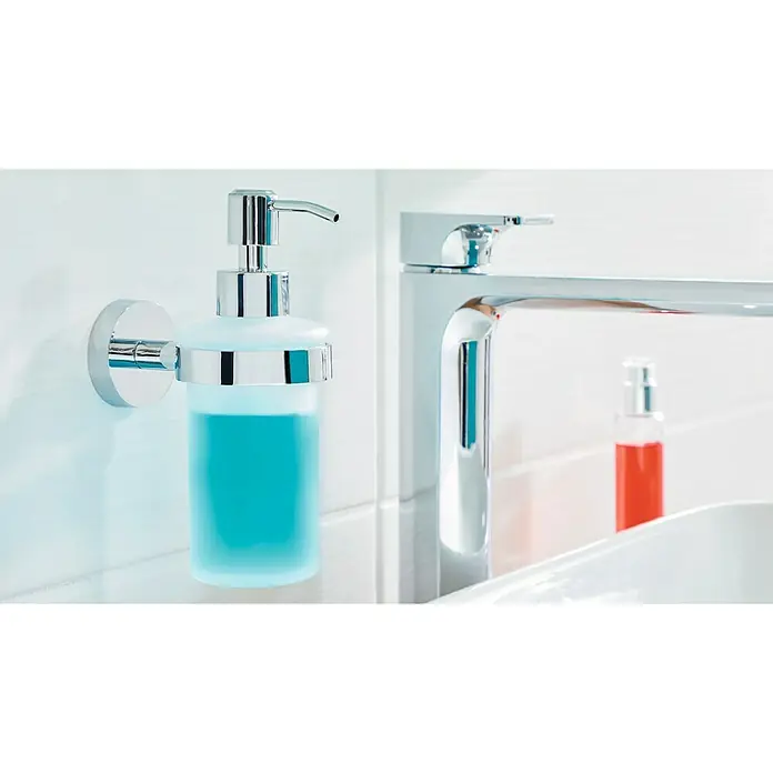 Tesa Smooz Seifenspender - Mit Halterung, Metall, Satiniert/Chrom - Bild eines Seifenspenders mit blauem Inhalt und einem chromfarbenen Wasserhahn, die eine moderne Badezimmerausstattung ergänzen.