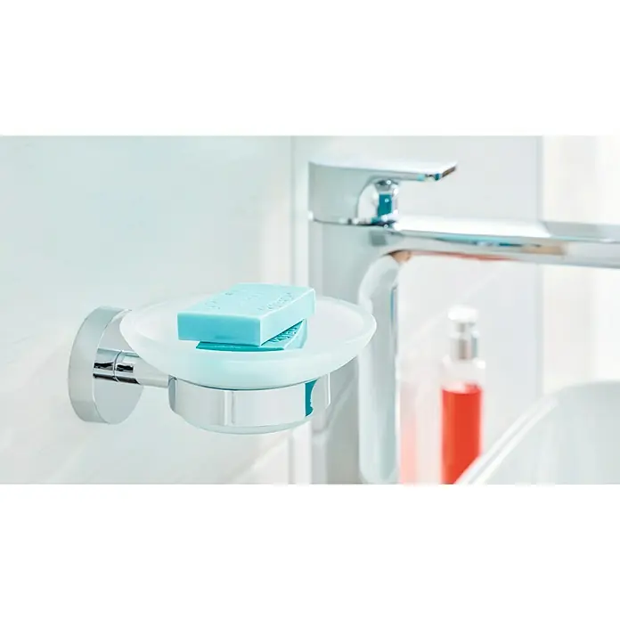 Tesa Smooz Seifenschale - Mit Halterung, Satiniert/Chrom, Glänzend - Nahaufnahme eines Seifenhalters mit blauer Seife darauf, montiert neben einem modernen Wasserhahn im Badezimmer.