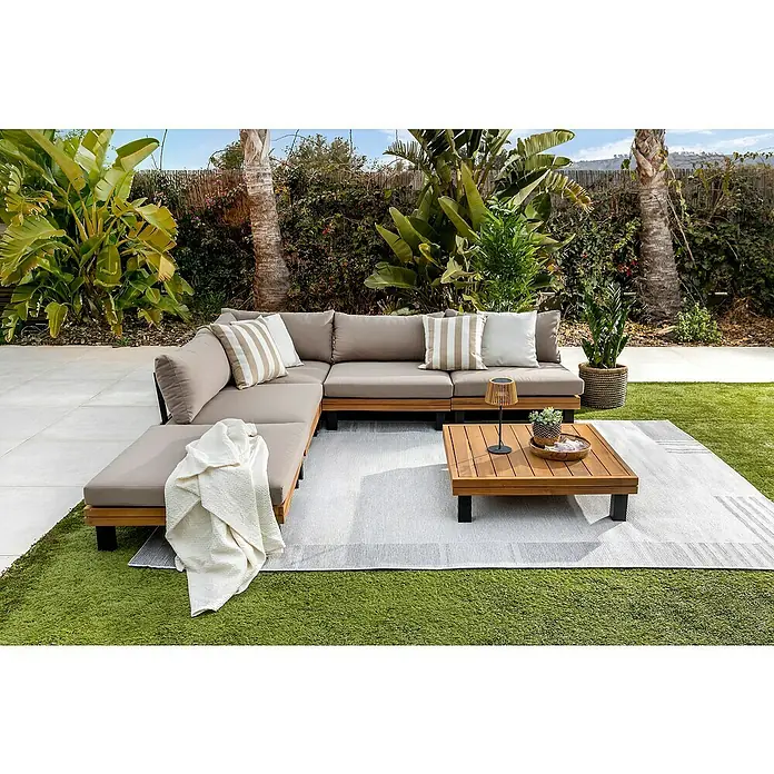 Conjunto de muebles Elsa - 6 pzs., Madera de acacia/Aluminio, Marrón - Un sofá seccional modular de exterior gris con una mesa de centro a juego sobre una alfombra de rayas en un entorno exterior.