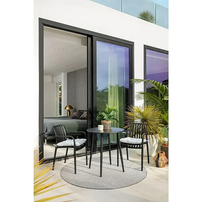 Alfombra exterior reversible Vichy - Gris, Diámetro: 160 cm, Polipropileno - Elegante juego de patio con mesa y sillas sobre una alfombra redonda, complementado con plantas decorativas.