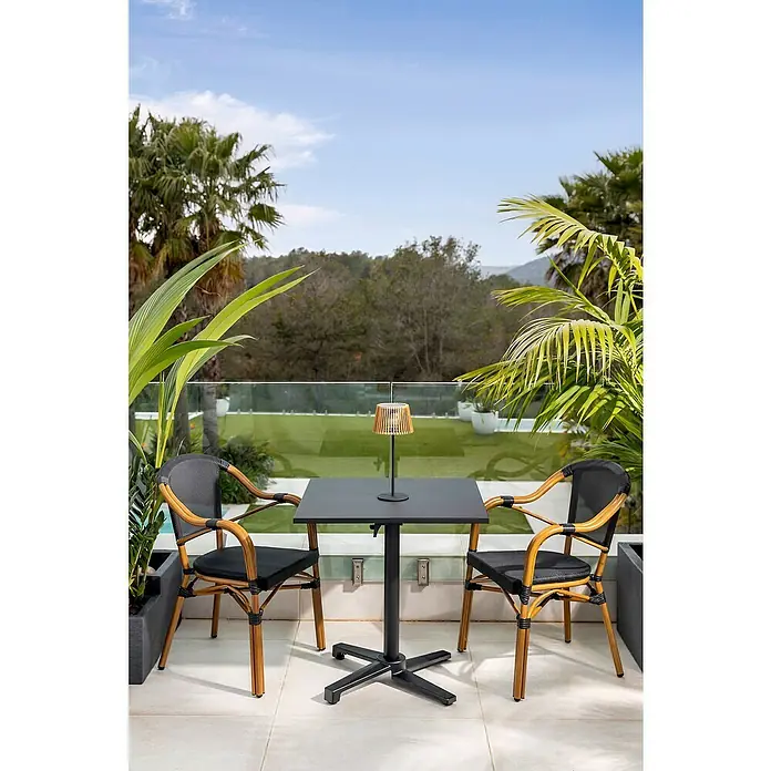 Mesa auxiliar de jardín Sibuco II - L x An x Al: 70 x 70 x 73 cm, Acero, Negro, Abatible - Mesa de jardín con dos sillas en una terraza. El conjunto incluye una mesa negra y sillas de mimbre con asientos negros.