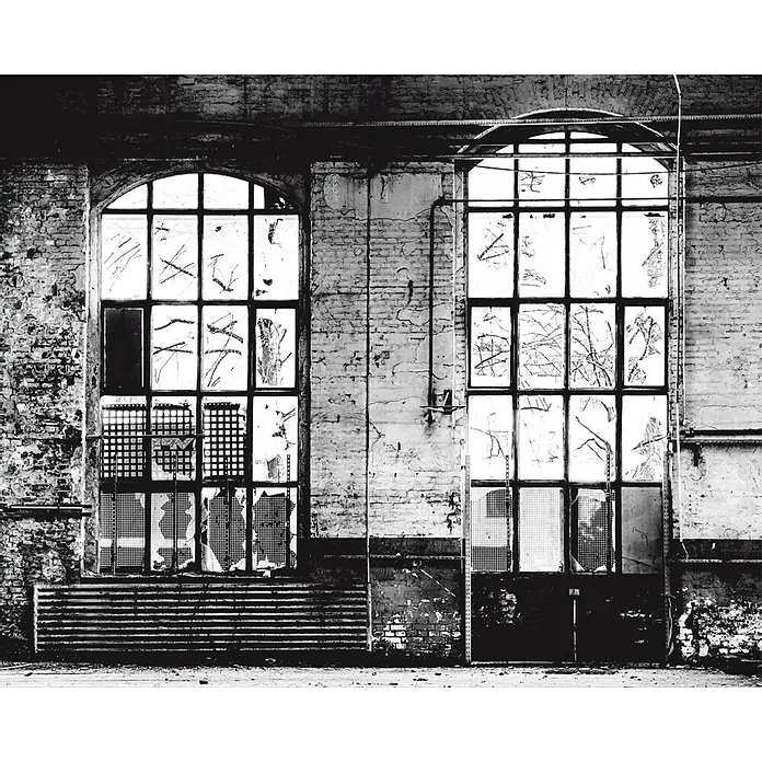 Rasch Fototapete Digitaldruck Industriehalle - B x H: 300 x 372 cm, Vlies - Verlassene Fabrik mit zwei großen Fenstern, die teilweise mit Gittern verdeckt sind und eine verfallene Atmosphäre schaffen.