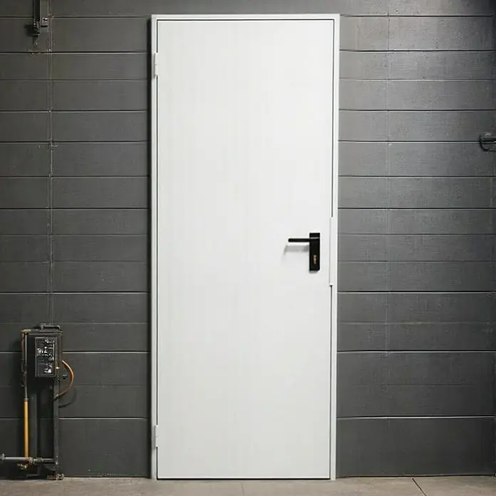 Novoferm Puerta de trastero Super Plus - 87,5 x 203,5 cm, Derecha - Puerta blanca con manija negra sobre una pared gris. Una puerta robusta y sencilla para espacios industriales o comerciales.