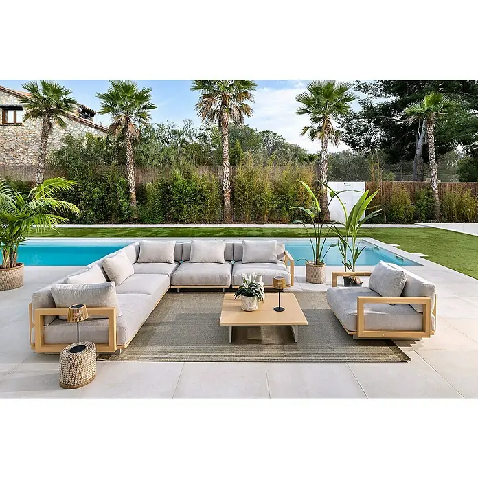 Sunfun Loungemöbel-Set Camelia - 7 -tlg., Aluminium, Polyester, Hellgrau/Holzoptik - Moderne Outdoor-Lounge-Gruppe mit großzügigem Ecksofa, Couchtisch und Sessel auf einer Terrasse mit Pool und Palmen.