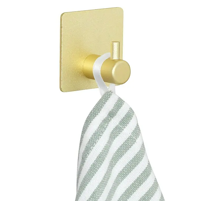 Wenko Colgador de baño Ureo - L x Al: 3 x 4,5 cm, Número de ganchos: 1 ud., Oro - Un gancho dorado sostiene una toalla a rayas. El gancho está fijado a una placa dorada que está montada en la pared.