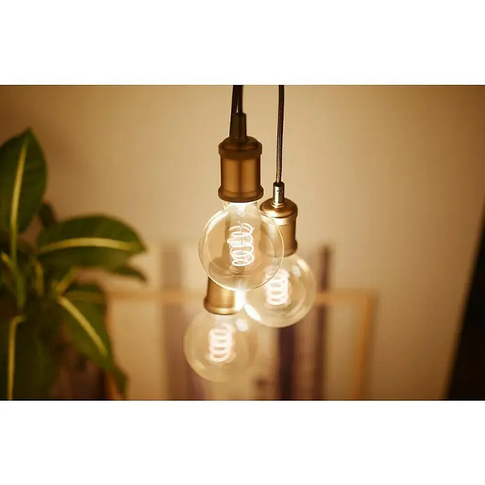 Philips Lámpara colgante LED Estándar - 40 W, L x An x Al: 7,1 x 16,9 x 16,9 cm, Oro, E27 - Primer plano de tres bombillas retro con filamentos en espiral y accesorios dorados, que emiten una luz cálida y acogedora.