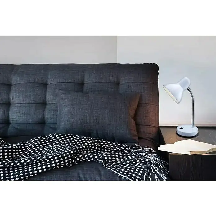 Globo Lámpara de sobremesa Basic - L x An x Al: 21,5 x 21,5 x 35 cm, 40 W, Blanco, E27 - Un cabecero gris acolchado con almohada y una manta blanca y negra en la cama. Una lámpara blanca está en la mesita de noche.