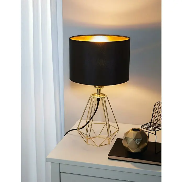 Eglo Lámpara de sobremesa Carlton 2 - 60 W, L x An x Al: 16,5 x 16,5 x 30,5 cm, Oro, E14 - Elegante lámpara de mesa con pantalla negra y base geométrica dorada, situada sobre una mesita de noche.