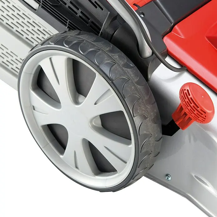 AL-KO Comfort Elektro-Rasenmäher Silver 46.4 E - 1.600 W, Schnittbreite: 46 cm - Detailaufnahme eines Rasenmäherrads mit grauem Felge und schwarzem Reifen, daneben ein roter Knopf zur Höheneinstellung.