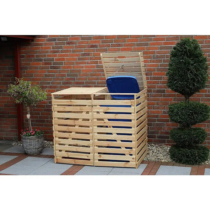 Promadino Mülltonnenbox Vario V -  - Ein zweifacher, hölzerner Mülltonnenunterstand mit einem blauen Müllbehälter, der teilweise sichtbar ist. Der Unterstand steht vor einer roten Backsteinmauer.
