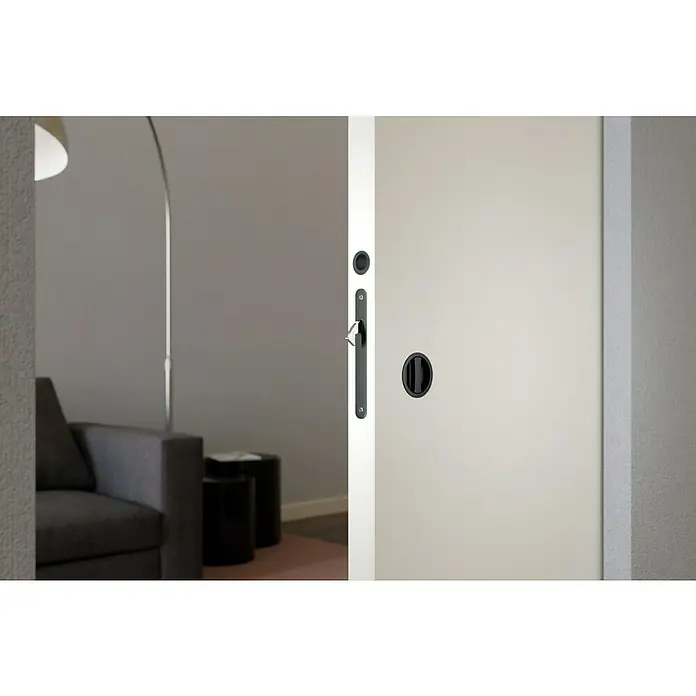 Entravia Schiebetürschloss WC - Beschlag geeignet für: Holzschiebetüren, Passend für: Entravia Simple-Pocket Schiebetürsystem, Schwarz - Nahaufnahme einer modernen Schiebetür mit einem eleganten schwarzen Griff und Schloss, die einen stilvollen Übergang zu einem Wohnbereich bietet.