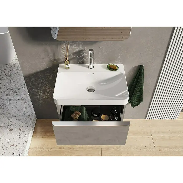 Riva Beauty 2.0 Waschtischunterschrank - B x T x H: 58,5 x 43,7 x 63,5 cm, Chromix Silver - Ein Waschbecken mit offenem Unterschrank, in dem Handtücher, Seife und Kerzen liegen. Helle Holzfußböden und graue Akzentwand.