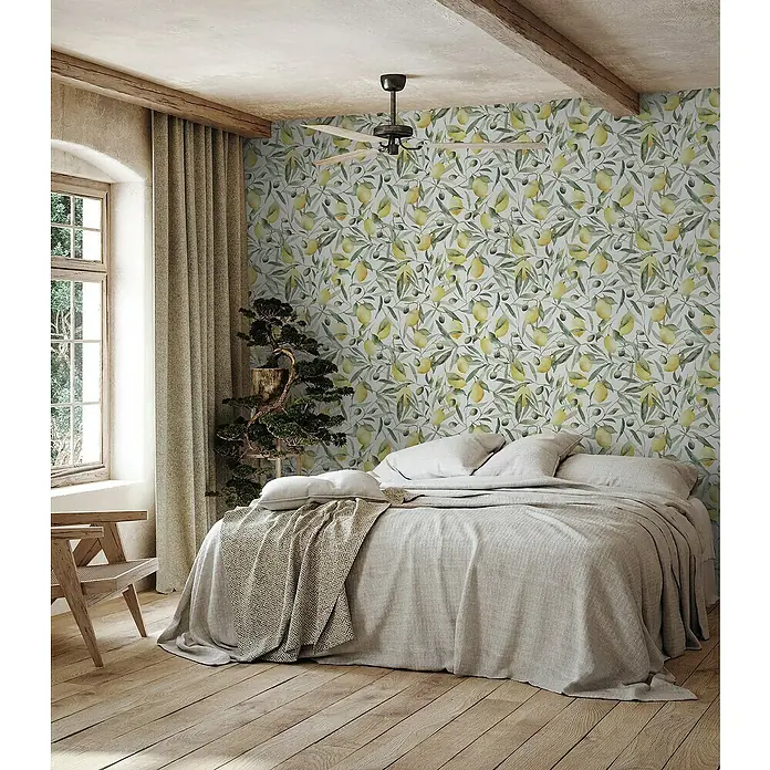 Glööckler Pompöös Provence Vliestapete Zitronen - Weiß/Grün/Gelb, Floral, 10,05 x 0,53 m - Ein Schlafzimmer mit einer Wandtapete mit Zitronenmuster, einem hellen Holzfußboden und einem passenden Bettbezug.